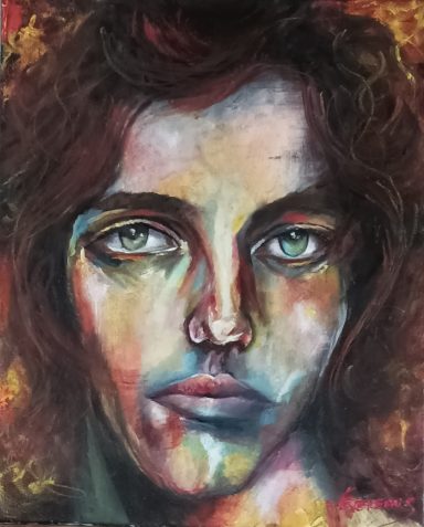 Portrait de jeune homme brun aux cheveux mi long.